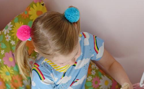 Child wearing pom pom hair bands Child wearing pom pom hair bands