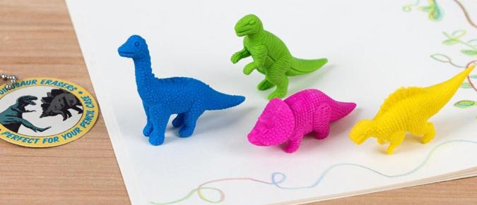 Dinosaur erasers on a notebook