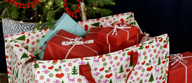 A festive jumbo bag with gifts poking out of the top