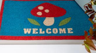 Colourful doormat featuring red mushroom and a welcome letter print