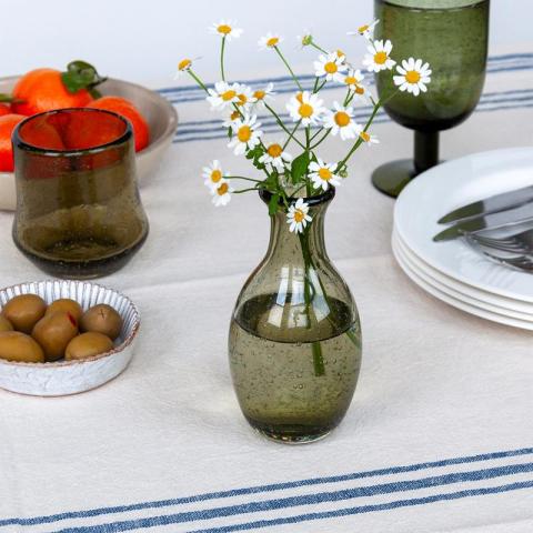 green vase with flowers on table