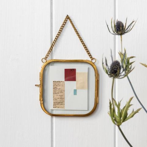 Frame hanging with flowers at side