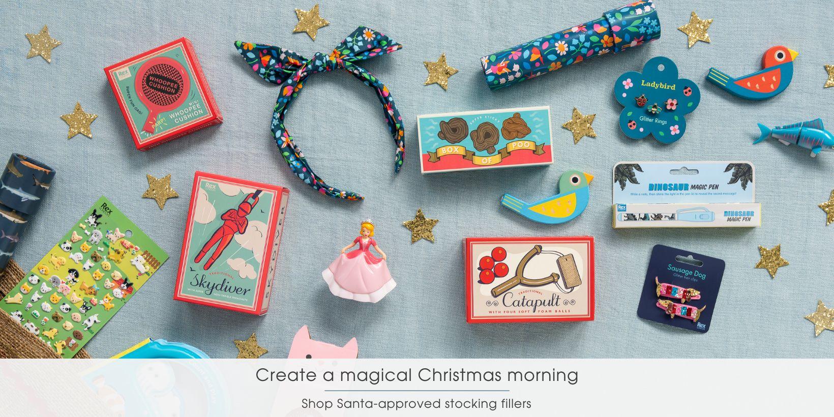 An array of stocking filler toys and games is spread out on a blue cloth