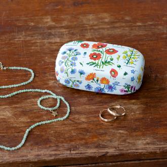 White mini travel case with print of wild flowers with jewellery to fit inside