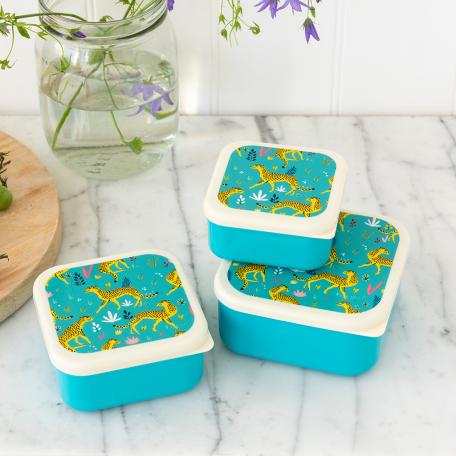 Three plastic snack boxes in turquoise and cream featuring prints of cheetahs