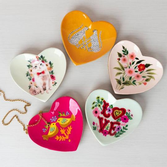 Five heart-shaped wooden trinket tray are shot from above, with a gold necklace laying on one